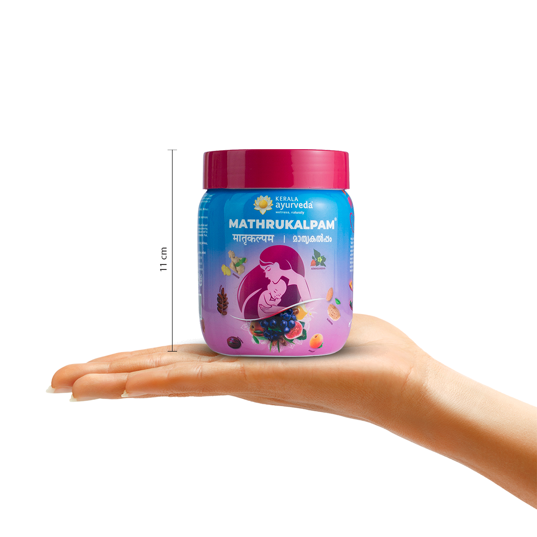 A hand holding a jar of Kerala Ayurveda Mathrukalpam, with a measurement indicator showing its height as 11 cm. The product name and mother-baby illustration are visible on the label. – Kerala Ayurveda India