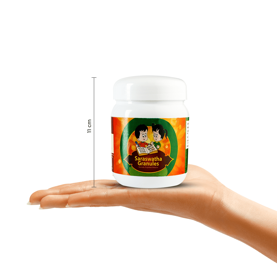 A hand holding a jar of Kerala Ayurveda Saraswatha Granules, with a measurement indicator showing its height as 11 cm. The product name and child illustration are visible on the label. – Kerala Ayurveda India