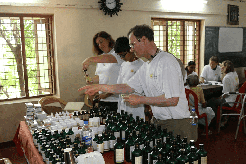 People examining and organizing various bottles and products in a workshop setting.