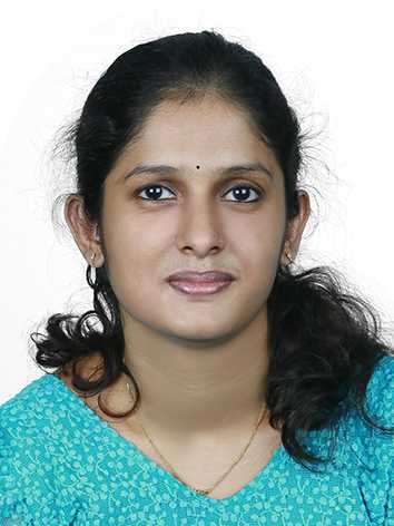 A woman with dark hair, wearing a turquoise top, smiling at the camera against a white background.