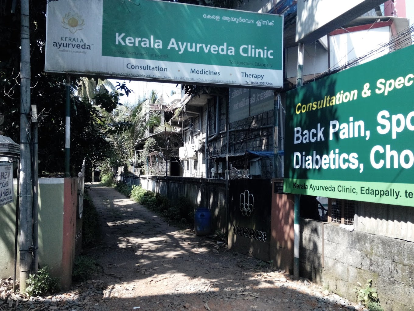 Entrance to Kerala Ayurveda Clinic with signs for consultations and specialties like diabetes and chiropractic care.