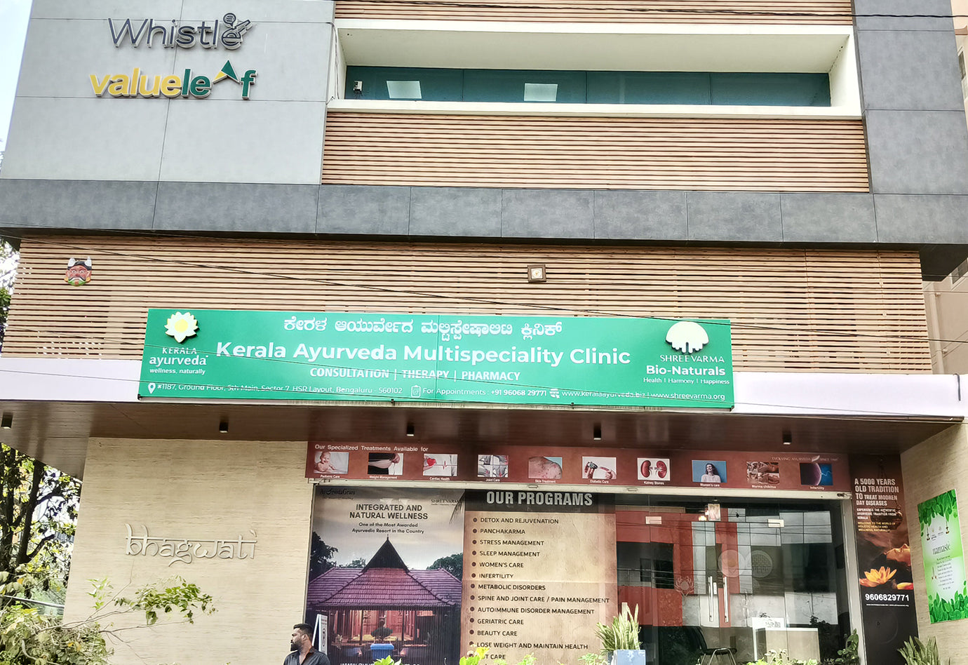 Sign for Kerala Ayurveda Multispeciality Clinic with information about services and programs.